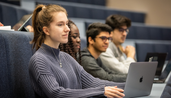 A group of students sitting in a lecture theatre.